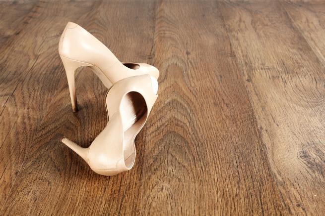 An image of high heels on a wooden floor